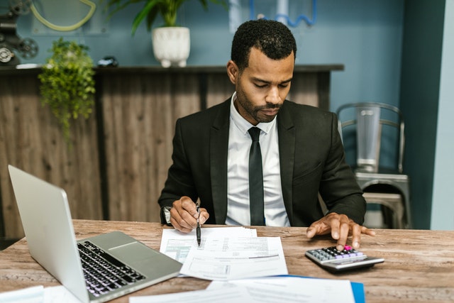 person reviewing documents and using a calculator